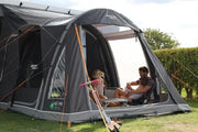 Vango Kela Pro Air Tall Drive Away Awning with Carport and Digital Pump - In Store, people enjoying a sunny day outdoors.
