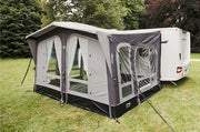 Vango Riviera 390 Awning Elements Pro Shield set up in a grass field near a caravan, showcasing its durable design.