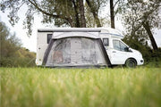 Vango Sunlight Air 380 Elements Proshield attached to a campervan on grass, providing a flexible outdoor living space.
